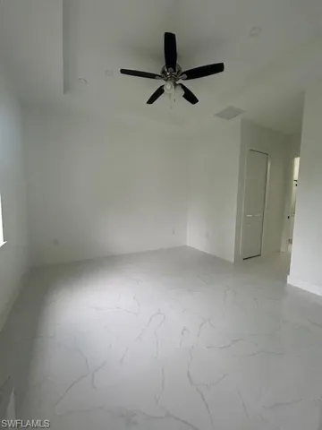 Spare room featuring light marble finish flooring and ceiling fan