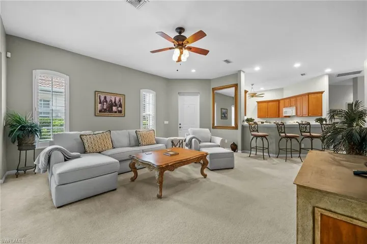 Living room featuring light carpet, a ceiling fan, and recessed lighting