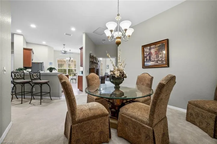 Dining room featuring a chandelier, light carpet, and recessed lighting