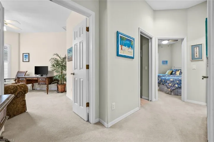 Corridor featuring a desk and light carpet