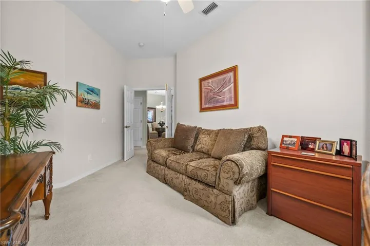 Living area featuring carpet and a ceiling fan