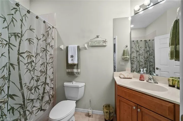 Bathroom with vanity, a shower with curtain, and light tile patterned floors