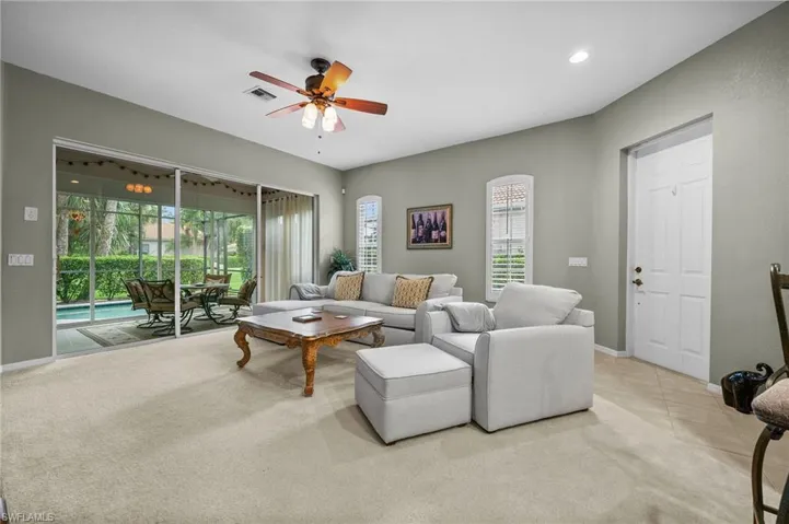 Living room with a ceiling fan, light tile patterned floors, light carpet, a sunroom, and recessed lighting