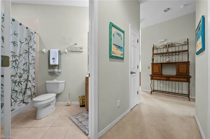 Bathroom with vanity, shower / tub combo with curtain, and light tile patterned floors