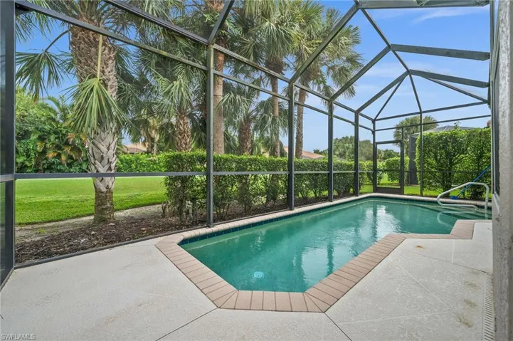 Swimming pool with a sunroom, a lanai, a patio, and a lawn
