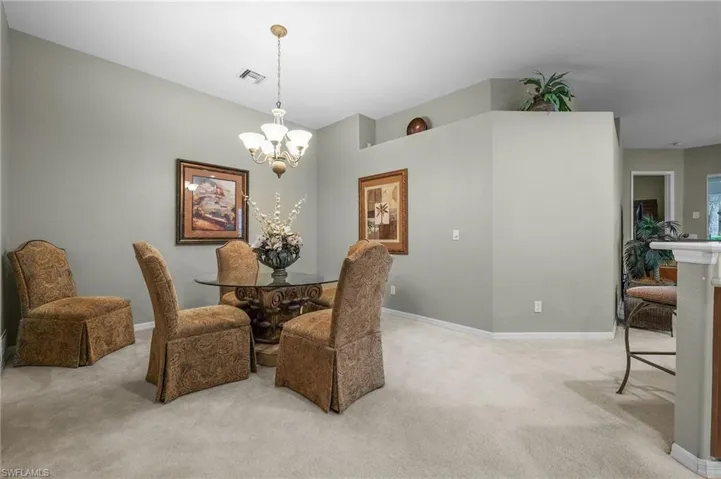 Dining area featuring light colored carpet and a chandelier