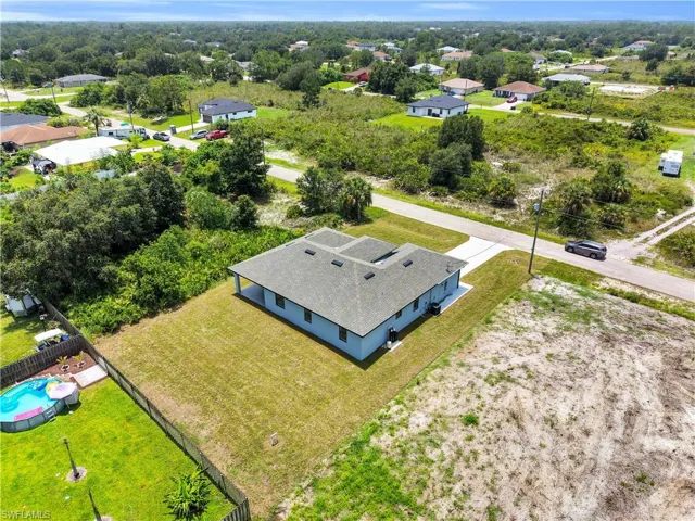 Light blue single-story residence featuring a dark shingle roof and a concrete driveway