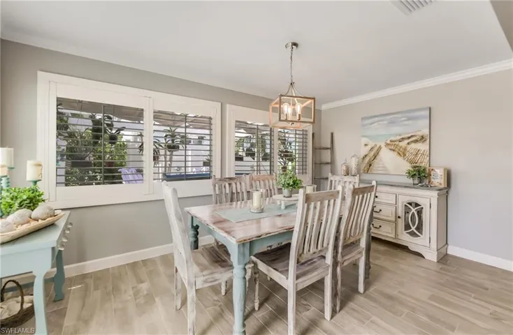 Dining area with a chandelier, crown molding, and light wood finished floors
