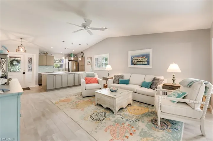 Living room with ceiling fan, lofted ceiling%2