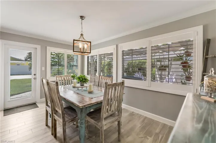 Bedroom featuring light wood-style floors, ornamental molding, ensuite bathroom, and ceiling fan