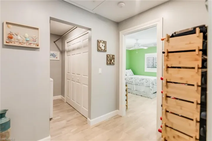 Washroom featuring cabinet space, washing machine and clothes dryer, and light wood-style flooring