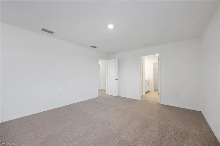 Unfurnished bedroom featuring carpet floors and ensuite bathroom