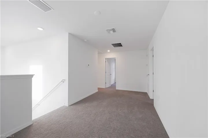Spare room with carpet and baseboards