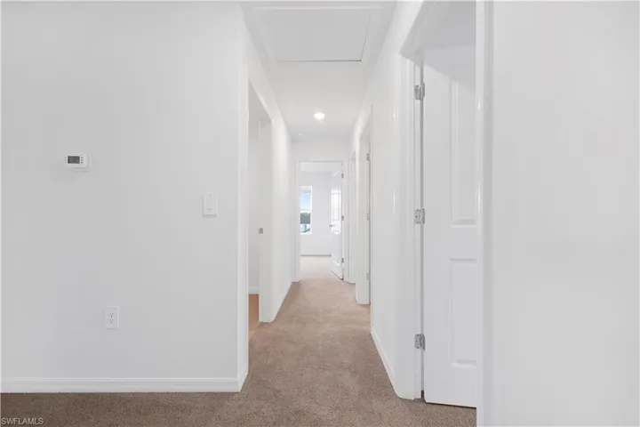 Hall featuring light carpet and recessed lighting