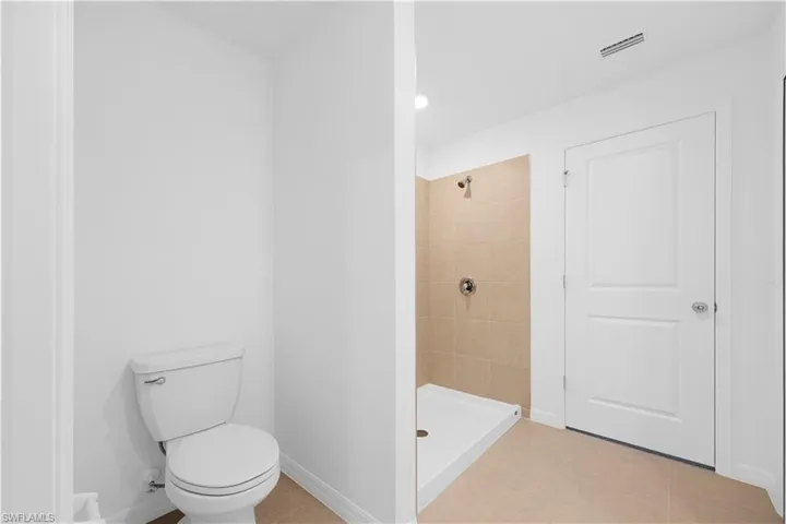 Full bath with a stall shower and light tile patterned flooring