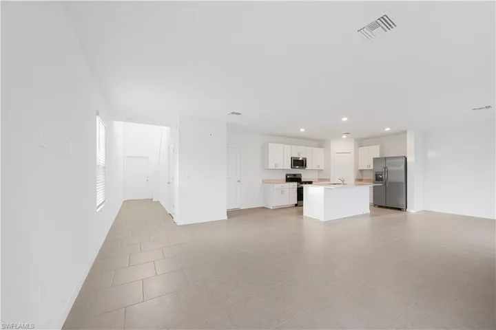 Unfurnished living room with recessed lighting and light tile patterned floors