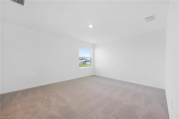 Empty room featuring light colored carpet and recessed lighting