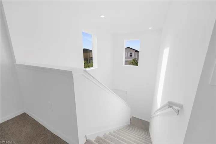 Stairway with carpet floors and recessed lighting