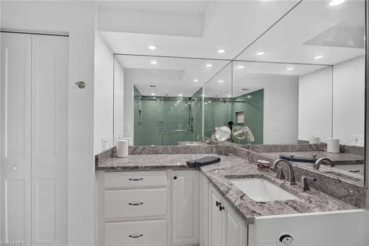 Large new vanity with plenty of space, custom plumbing and lighting fixtures. Linen closet.