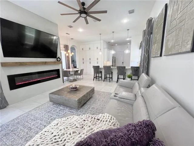 Living room featuring ceiling fan and light tile patterned floors