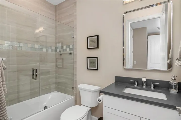 Ensuite guest bath with frameless glass shower enclosure.