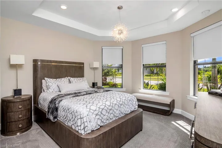 Guest bedroom at front of home includes ensuite bath and large closet with custom built-in shelving.