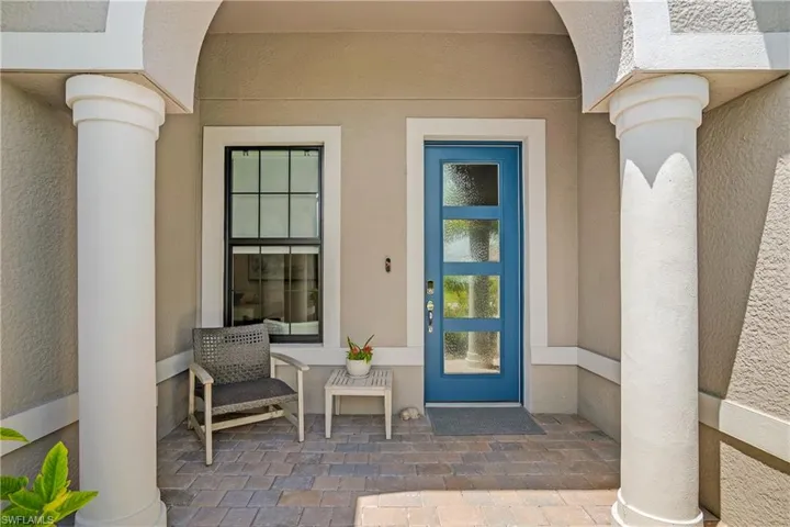 Welcoming entryway and covered front porch with glass pane door.