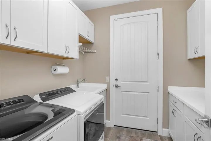 Laundry room includes additional cabinetry for extra storage.