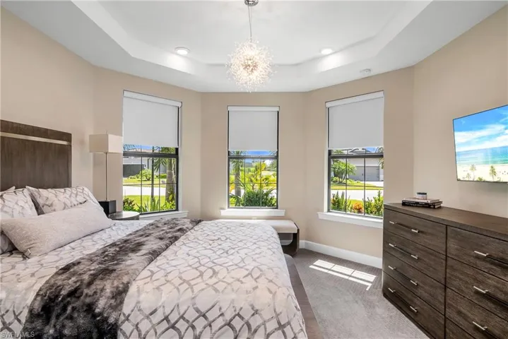 Guest bedroom at front of home includes ensuite bath and large closet with built-in shelving.