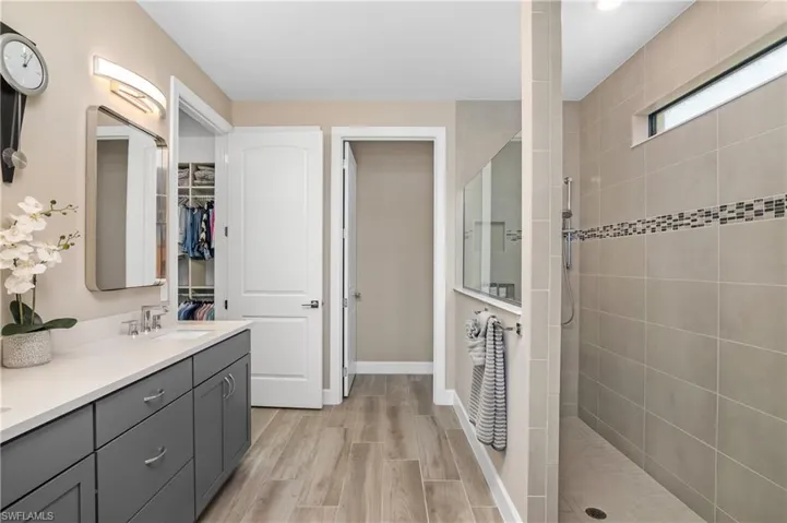 Owner bath with oversize walk-in shower, custom tile, dual sinks, and upgraded lighting and mirrors.