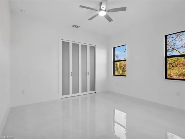Unfurnished bedroom with ceiling fan and a closet