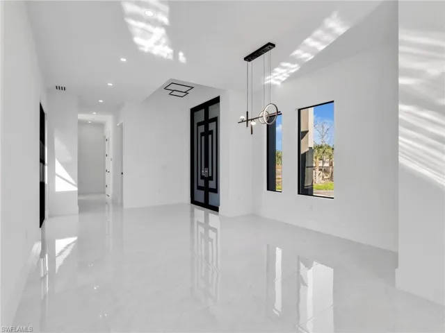 Hall with french doors and a chandelier
