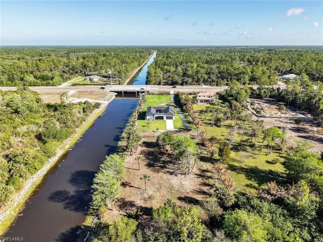 Drone / aerial view of a nearby body of water and a forest