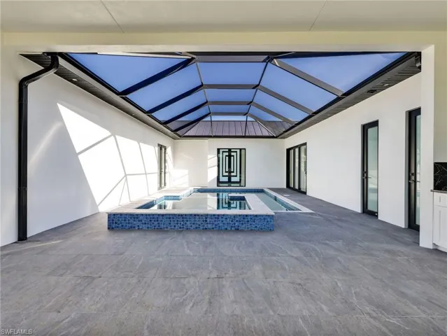 Swimming pool with a sunroom, an in-ground hot tub, a patio, and a lanai