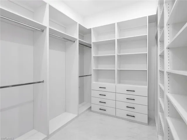 Walk in closet featuring light marble finish floors