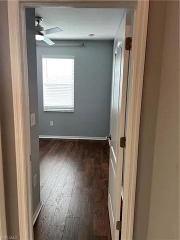 Spare room with dark wood finished floors and a ceiling fan