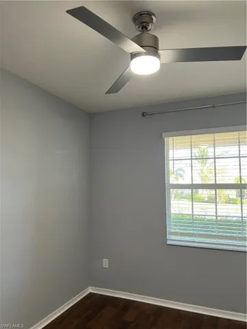 Spare room featuring dark wood-style floors and ceiling fan