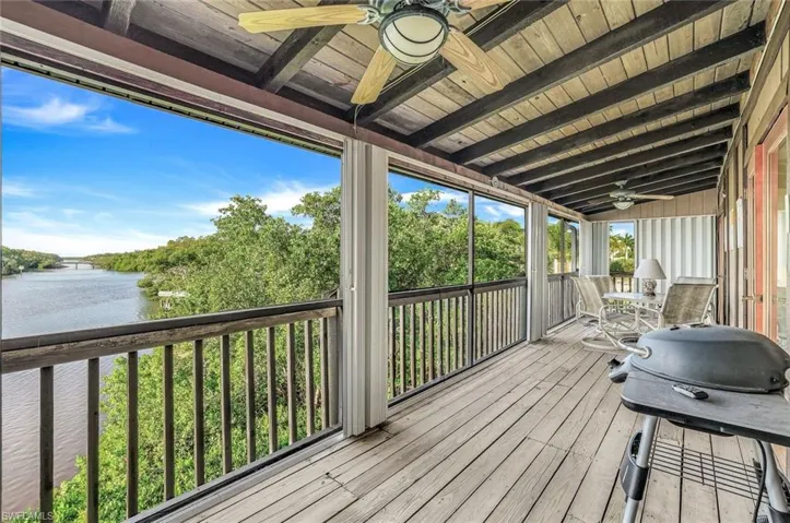 Wooden deck with ceiling fan and a water view