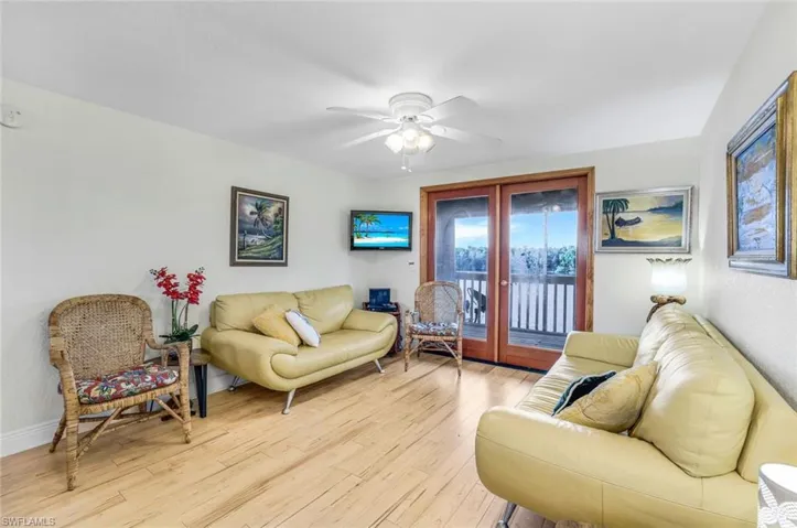 Living room with light hardwood / wood-style floors and ceiling fan