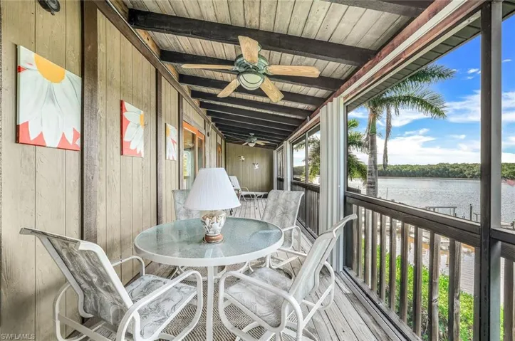 Sunroom / solarium featuring ceiling fan, vaulted ceiling with beams, a water view, and wood ceiling