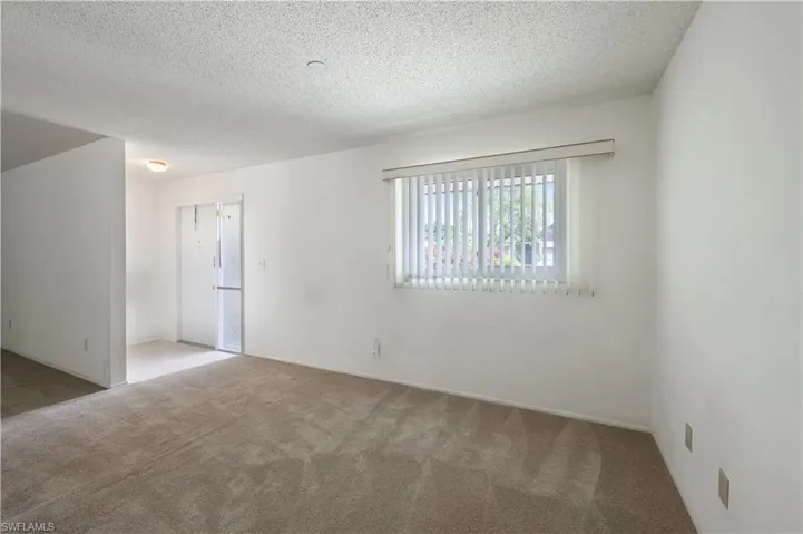 Spare room featuring carpet and a textured ceiling