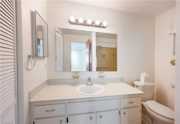 Bathroom with vanity and a closet