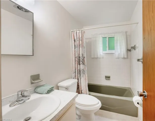 Bathroom featuring vanity and shower / tub combo with curtain Guest