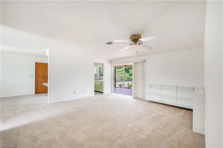 Spare room with carpet flooring, ceiling fan, and a textured ceiling