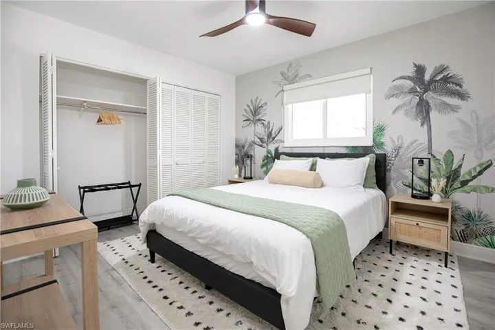 2nd bedroom featuring ceiling fan, a closet, queen bed, nightstands