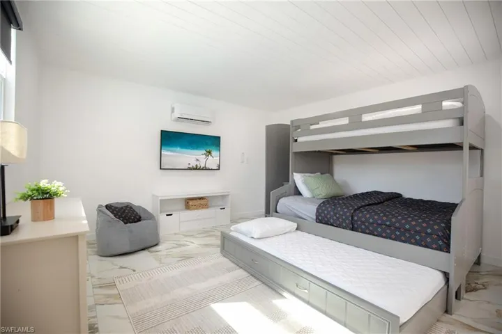 Den featuring kids' room with marble look tiles, bunk bed, dresser, AC