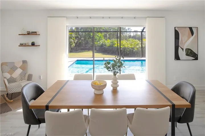 Dining area with a beautiful pool view and cozy reading nook on the left