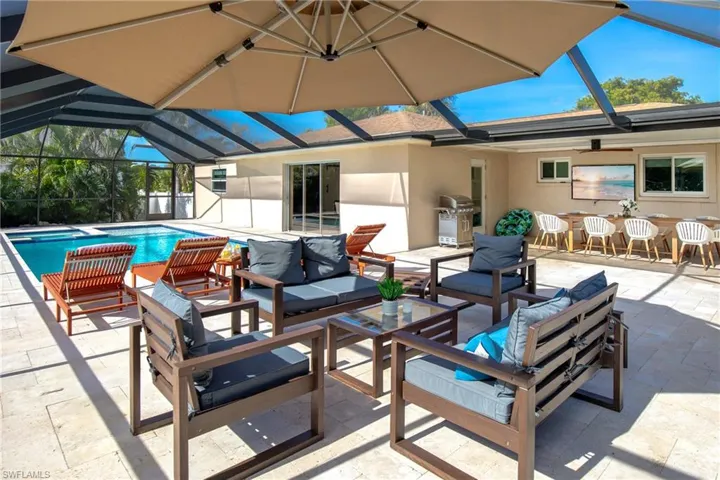 View of a screened pool, patio, lanai, outdoor dining area and BBQ