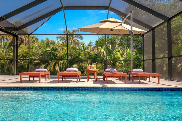 Outdoor screened pool featuring lounge chairs
