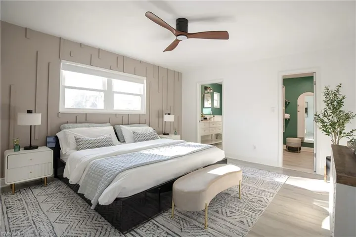 Primary bedroom with king bed, ceiling fan, nightstands, ensuite bathroom and walk-in closet